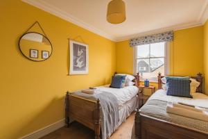 En eller flere senge i et værelse på Harbour Master by Keepers Cottages