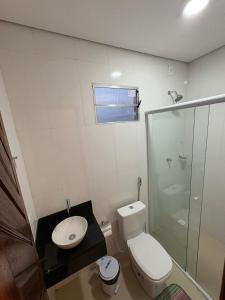 a white bathroom with a toilet and a shower at Recanto Mandacaru in Queimada