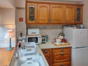 a small kitchen with a sink and a microwave at Cow Cottage in Langford