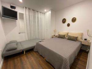 ein Schlafzimmer mit großem Bett und Fernseher in der Unterkunft Casa da Covilhã - Pedra e Lã in Covilhã + 19 Fotos