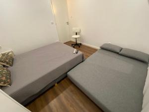 2 Betten in einem kleinen Zimmer mit in der Unterkunft Casa da Covilhã - Pedra e Lã in Covilhã