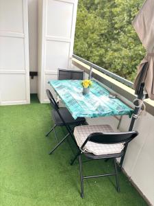 a table and chairs on a balcony with grass at Cozy appartement in oberbarmen in Wuppertal +8 photos