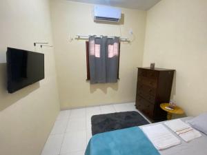 a bedroom with a bed and a television and a dresser at Recanto Buriti in Barreirinhas +11 photos