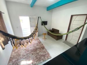 a hammock hanging in a room with a couch at Recanto Buriti in Barreirinhas