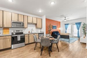 Adeline Apartments 15m to Parks, Pet Friendly, Free Parking by Heavenly Homes في أورلاندو: مطبخ وغرفة معيشة مع طاولة وكراسي