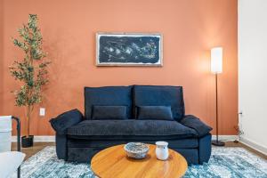 Adeline Apartments 15m to Parks, Pet Friendly, Free Parking by Heavenly Homes في أورلاندو: غرفة معيشة مع أريكة زرقاء وطاولة