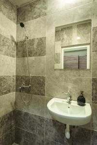 a bathroom with a sink and a shower at Maracuya Apartment in Veliko Tŭrnovo