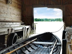 an old boat sitting in the water in a barn at 5 person holiday home in VÄDDÖ in Veda +11 photos