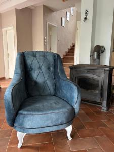 a blue chair sitting in a living room with a fireplace at Villa Ela in Prijedor +49 photos
