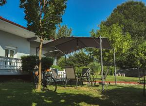 a table and chairs under an umbrella in a yard at Deppy's House κοντά στα λουτρά Πόζαρ in Chrysí