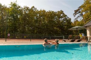 two people are in a swimming pool at Tilia Kúria - Adults only in Bózsva +26 photos