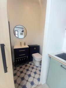 a bathroom with a toilet and a sink and a mirror at The Dutch Barn in Maidstone