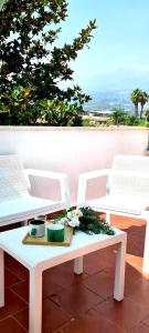 a table with two chairs and flowers on it at La mansardina sul mare - Mascali in Mascali +10 photos