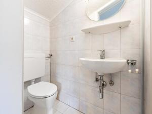 a white bathroom with a toilet and a sink at Apartment Uttendorf near Ski Slopes in Uttendorf