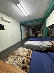 a room with two beds with a leopard blanket on the floor at EcoRally Stay in Bella Vista