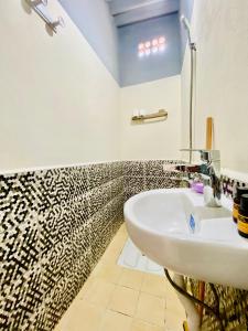 a bathroom with a sink and a black and white patterned wall at Plage à Pied Refuge Relaxant Design Moderne in Tamaris +13 photos