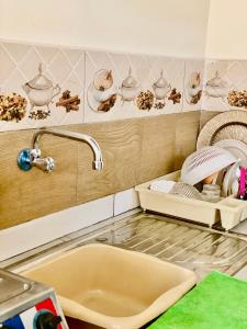 a kitchen counter with a sink and a faucet at Charmant logement à 2 min de la plage de tamaris in Tamaris