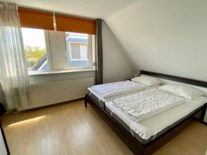a small bedroom with a bed and a window at Bohemien Resort 21 in Sint Maartenszee