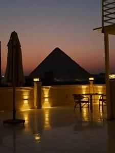 a patio with an umbrella and a table at Grand Pyramid View Hotel in Cairo +119 photos