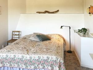 a bedroom with a bed with a blanket and a lamp at 4 star holiday home in Åskloster in Åskloster