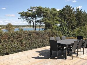 a table and chairs on a deck with a view of a lake at 4 star holiday home in Åskloster in Åskloster