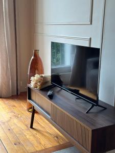 a living room with a flat screen tv on a table at L appartement de Jeanne in Compiègne