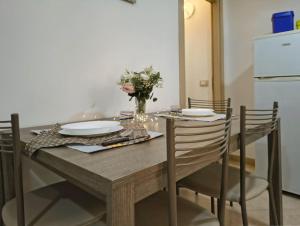 a dining room table with plates and a vase of flowers at Home AGM in Pozzallo