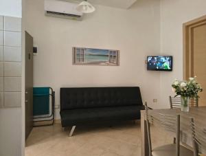 a living room with a black couch and a table at Home AGM in Pozzallo