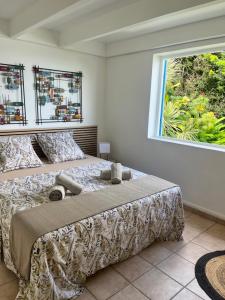 una camera da letto con un letto grande e una finestra di Bungalow Corossol a Deshaies