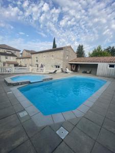 a large blue swimming pool in front of a house at Gîte 6p Ardèche ,Ruoms centre, climatisé avec piscine in Ruoms