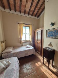 una camera da letto con due letti e una finestra di Agriturismo Case Corboli appartamento Visietto a Todi Altre 36 foto