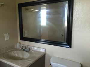 a bathroom with a sink and a mirror and a toilet at Pelican Inn & Suites in Toms River