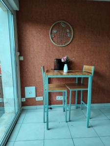 a table with two chairs and a pot with flowers on it at Chez Pam et David in Saint-Maixent-lʼÉcole
