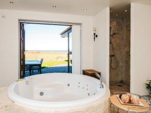 Una bañera grande en un baño con ventana. en Luxury Fjordview Retreat-By Traum, en Højslev