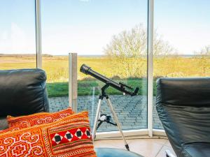 a telescope sitting on a tripod in front of a window at 5 star holiday home in Højslev in Højslev +46 photos