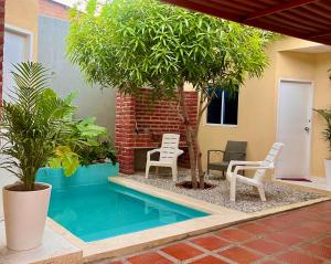 a swimming pool in a house with chairs and trees at Casa Agarj in Santa Marta