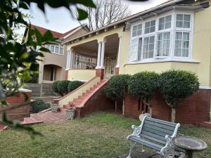 a bench sitting in front of a house at Glenwood Cottage 5km from beach, Art gallery, with garden and pool in Durban