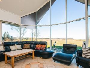 a living room with a couch and a table and chairs at 5 star holiday home in Højslev in Højslev