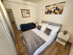 a bedroom with a bed and a blue couch at Apartment Golden Oak in Dubrovnik