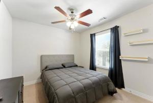 a bedroom with a bed and a ceiling fan at Luxury Home Mins to JPS & Medical City Fort Worth in Fort Worth