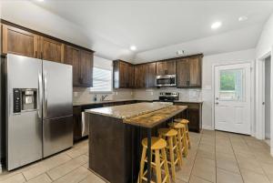 a kitchen with wooden cabinets and stainless steel appliances at Luxury Home Mins to JPS & Medical City Fort Worth in Fort Worth