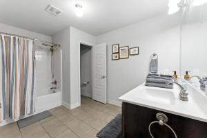 a white bathroom with a sink and a shower at Luxury Home Mins to JPS & Medical City Fort Worth in Fort Worth +16 photos