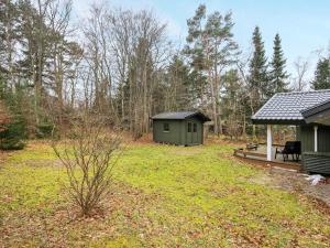 a green shed in a yard next to a house at 6 person holiday home in Frederiksværk-By Traum in Frederiksværk