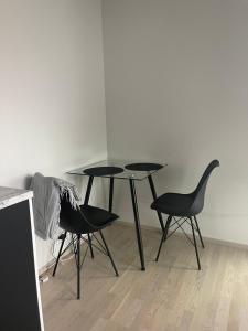 タンペレにあるBright and cozy studioの黒いテーブルと椅子2脚