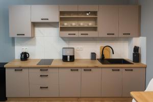 a kitchen with white cabinets and a sink and a counter at Apartamenty na Widoku Chłopy in Chłopy