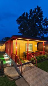a small yellow and red house with a patio at The Laughing Woods AC Resort in Kotagiri