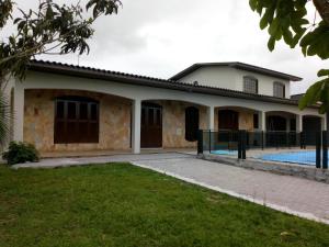 a house with a swimming pool in front of it at Casa geminada com piscina exclusiva in Arroio do Sal