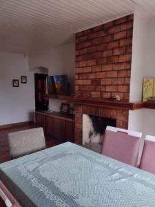 un soggiorno con camino, tavolo e sedie di Casa geminada com piscina exclusiva ad Arroio do Sal Altre 14 foto