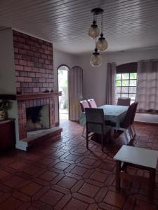 un soggiorno con tavolo e camino di Casa geminada com piscina exclusiva ad Arroio do Sal