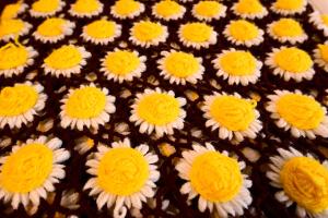 a blanket with yellow and white flowers on it at Little Italy Rooms in Perugia